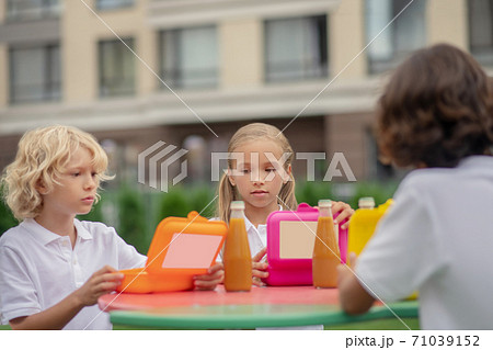 Children having lunch together and looking thoughtful 71039152