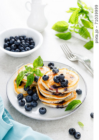 Blueberry pancakes with fresh berries on breakfast table 71039999