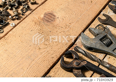 Old vintage household bolts, nuts and hand tools still life on a wooden background in a DIY and repair concept 71043929