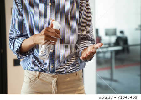 Work during quarantine. Cropped shot of female office worker using hand sanitizer spray while standing indoors 71045469