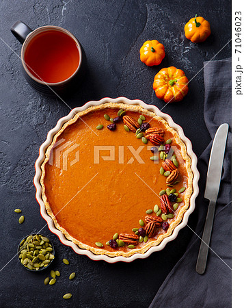 Pumpkin pie on marble board with cup of tea. Grey background. Close up. Top view. 71046023
