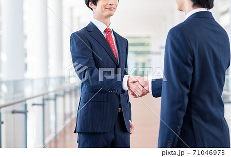 オフィスで握手をするビジネスマンの写真素材