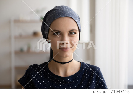 Head shot portrait attractive hairless woman wearing head scarf 71048512