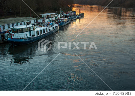 Many boats that are parked on the Thames 71048982