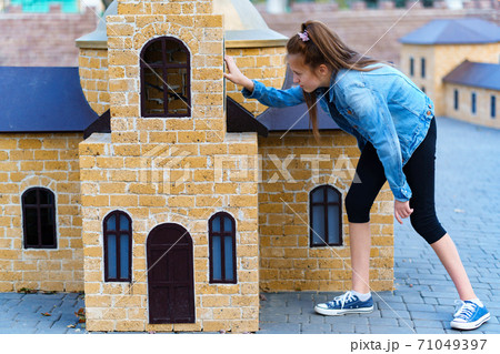 girl plays in a city Park with miniature houses girl plays in a city Park with miniature houses 71049397