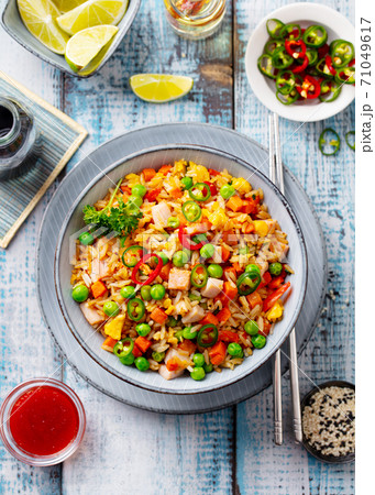 Asian fried rice with vegetables and ham. Blue wooden background. Copy space. Top view. Asian fried rice with vegetables and ham. Blue wooden background. Copy space. Top view. 71049617