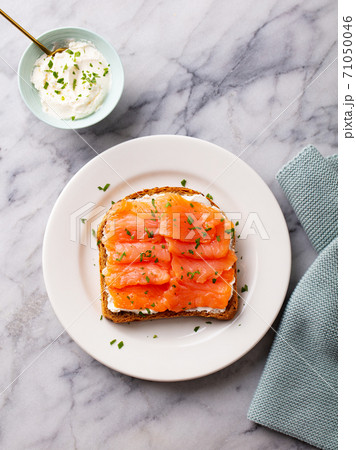 Sandwich, toast with smoked salmon and cream cheese on white plate. Marble background. Top view. 71050046