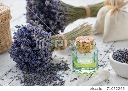 Lavender essential oil bottle, mortar, sachet bags and bouquets of dried lavender flowers. 71052266