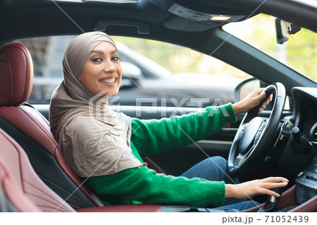 Smiling muslim woman driving her new car 71052439