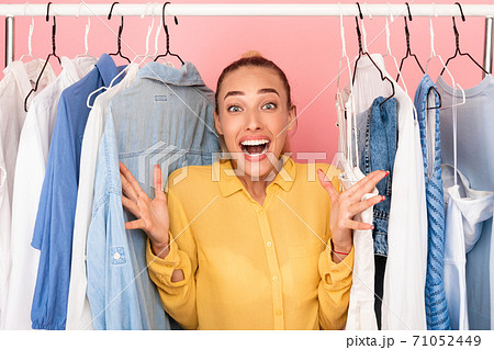Overjoyed lady screaming with joy choosing clothes Overjoyed lady screaming with joy choosing clothes 71052449