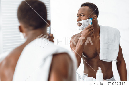 Shirtless Black Guy Shaving Face In Morning Standing In Bathroom Shirtless Black Guy Shaving Face In Morning Standing In Bathroom 71052515