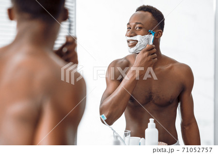 Shirtless African Man Shaving Face Covered With Foam In Bathroom 71052757