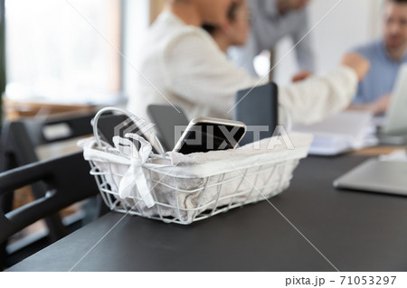 Close up basket with electronic gadgets smartphones standing on table. Close up basket with electronic gadgets smartphones standing on table. 71053297
