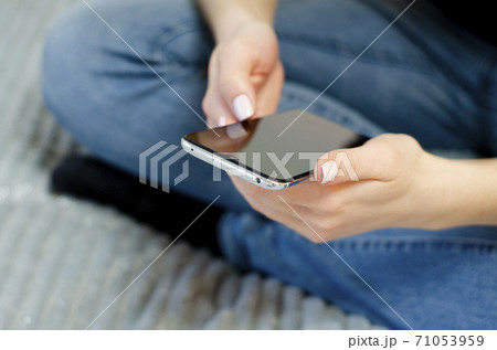 A young girl is using her mobile phone. Communication at a distance. A young girl is using her mobile phone. Communication at a distance. 71053959
