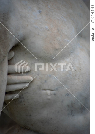 Jesus's wound and Mary's hand touching him, stone cemetery statue. 71054143