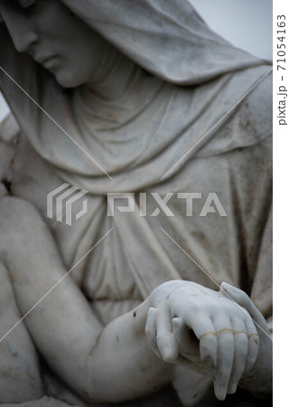 Stone cemetery statue, Mary holding Jesus's hand. Stone cemetery statue, Mary holding Jesus's hand. 71054163