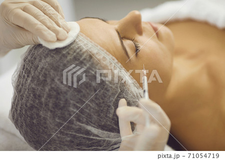 Hands of woman cosmetologist making botox injection for woman in beauty spa salon 71054719