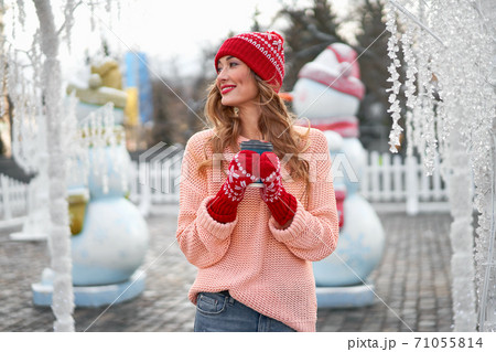 Beautiful lovely middle-aged girl with curly hair warm winter sweater stands background Town Square. Beautiful lovely middle-aged girl with curly hair warm winter sweater stands background Town Square. 71055814