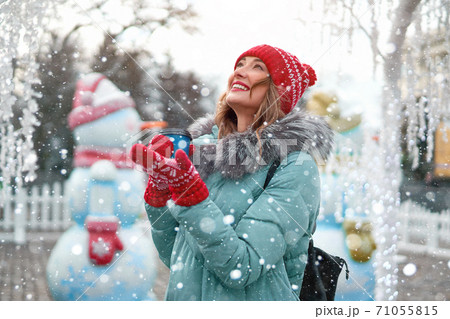 Beautiful lovely middle-aged girl with curly hair warm winter jackets stands ice rink background Town Square. 71055815