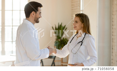 Young woman therapist welcoming new teammate in clinic office Young woman therapist welcoming new teammate in clinic office 71056058