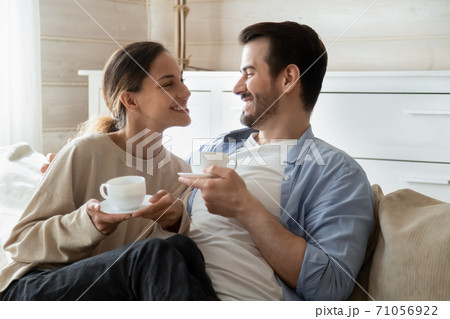 Happy married couple drinking tea enjoy being at home together Happy married couple drinking tea enjoy being at home together 71056922