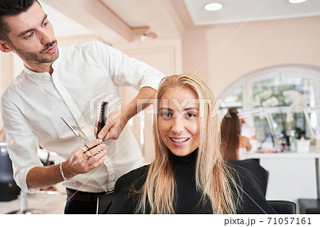 Hairdresser making a stylish hairdo Hairdresser making a stylish hairdo 71057161