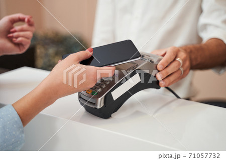 Woman paying with card contactless i Woman paying with card contactless i 71057732