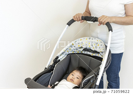 ベビーカーに乗る赤ちゃんと押す母親、生後4か月、女の子 71059622