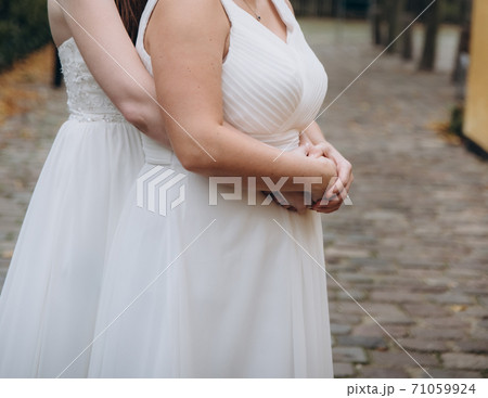 Newlywed lesbian couple on their happy wedding day wearing white dresses. Equality concept. Newlywed lesbian couple on their happy wedding day wearing white dresses. Equality concept. 71059924