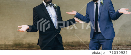 Newlywed stylish gay couple on their happy wedding day. Equality concept. Newlywed stylish gay couple on their happy wedding day. Equality concept. 71059925