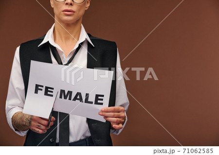 Midsection of manlike woman in elegant suit cutting syllable fe from word female Midsection of manlike woman in elegant suit cutting syllable fe from word female 71062585