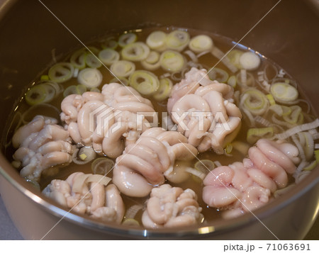 鍋で茹でる真タラの白子とネギ。 71063691
