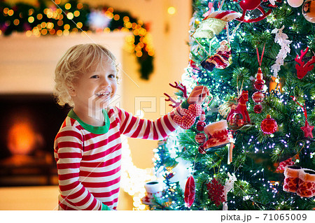Child decorating Christmas tree. Kid on Xmas eve. 71065009