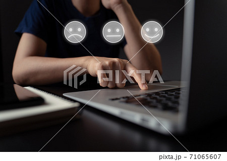 Woman using laptop and emoticon hologram effect. Woman using laptop and emoticon hologram effect. 71065607