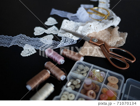 a stack of fabrics and sewing accessories on a tailor's table 71070134