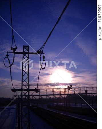 Winter northern short day. Low polar sun. Silhouette of a high voltage power line Winter northern short day. Low polar sun. Silhouette of a high voltage power line 71070506