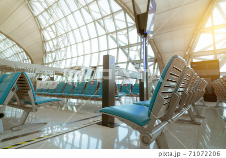 Selective focus on seat in departure lounge at airport terminal. Distance for one seat keep distance to protect coronavirus and passenger social distancing. Glass window at airport gate terminal. 71072206