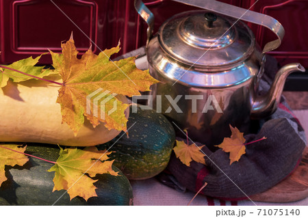 Old kettle, yellow leaves by the stove in the house Old kettle, yellow leaves by the stove in the house 71075140