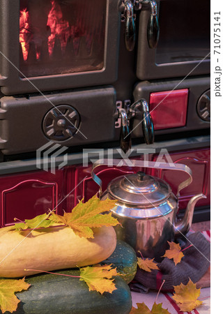 Old kettle, yellow leaves by the stove in the house Old kettle, yellow leaves by the stove in the house 71075141