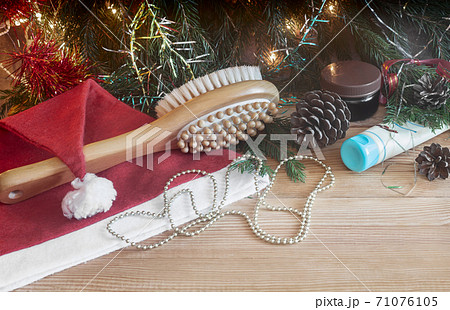 Massage brush and Christmas decorations on wooden background. 71076105
