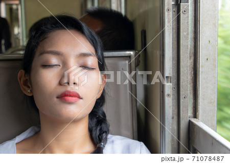 Portrait of young woman sleeping in the train. Passenger sleep in the old wagon of a train. 71078487