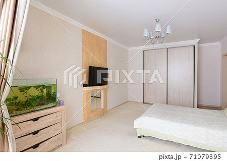 Interior of a spacious bedroom, stands an aquarium, TV and wardrobe 71079395