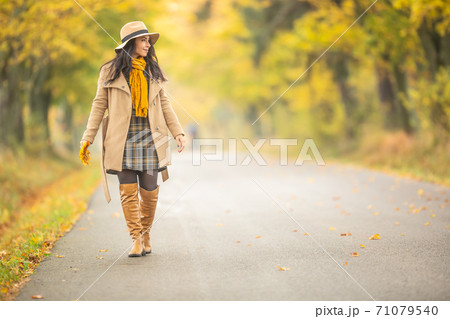 Young fashionably dressed woman walks in the colorful fall nature 71079540