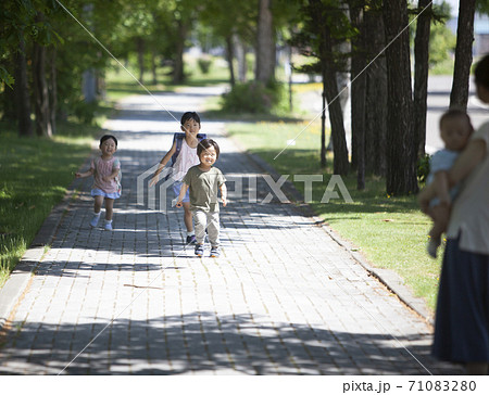 両親のところに走ってくる子供達の写真素材