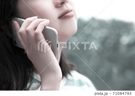 スマホで電話する女性。アンニュイな雰囲気。 スマホで電話する女性。アンニュイな雰囲気。 71084793