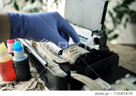 Refilling printer cartridges with multi-colored ink. Background Refilling printer cartridges with multi-colored ink. Background 71085876