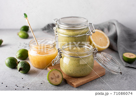feijoa mashed with lemon and honey in glass jars on a light background feijoa mashed with lemon and honey in glass jars on a light background 71086074