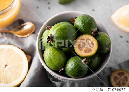 ripe feijoa with lemon and honey on a white table 71086075