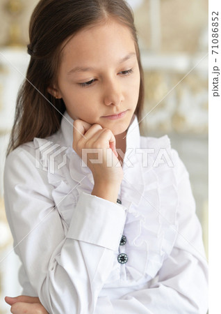 Portrait of cad little girl in white blouse posing at home 71086852