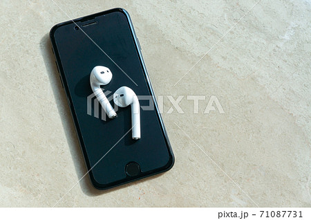 白いワイヤレスイヤホンとスマホ 白いワイヤレスイヤホンとスマホ 71087731